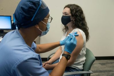 A volunteer receives a Moderna injection in a clinical trial involving more than 30,000 participants