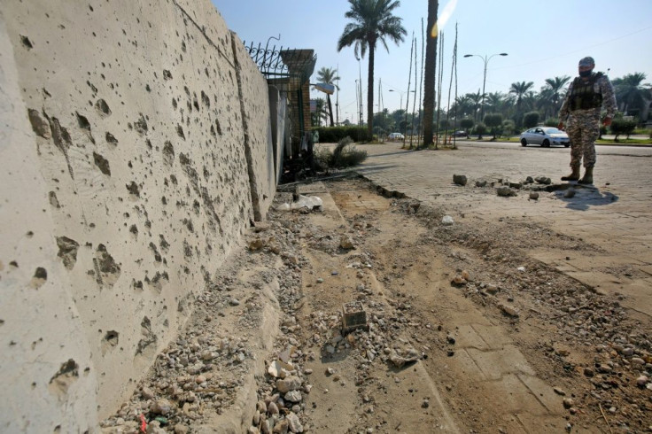 A member of the Iraqi security forces inspects damage from a volley of rockets that slammed into Baghdad after a month-long truce on attacks against the US embassy