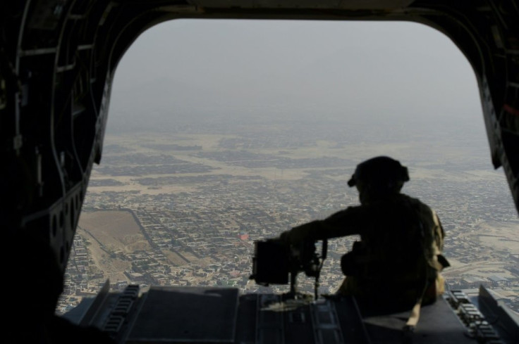 A US soldier sits on the ramp of a Chinook helicopter while flying over Kabul. Washington has announced plans to hasten the withdrawal of US forces
