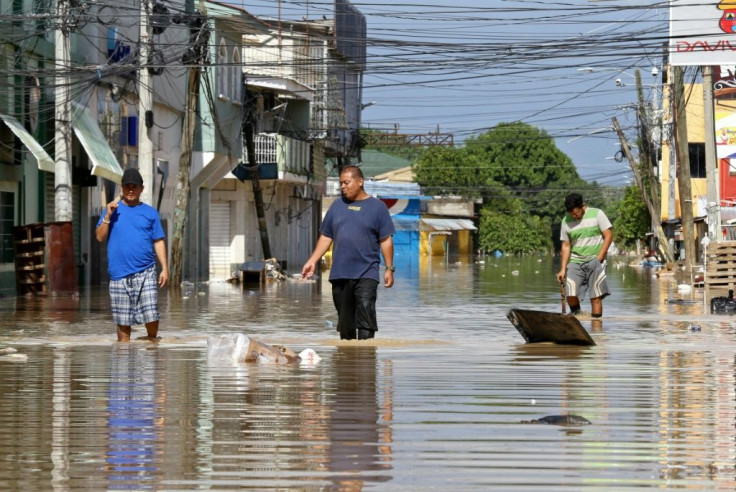 Men wade through floodwaters left behind by Hurricane Iota in La Lima, near San Pedro Sula in Honduras, on November 19, 2020