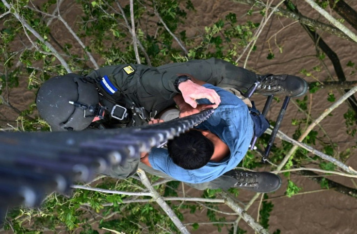 A man who got trapped in a flood and was clinging to a tree is rescued by members of the Honduran Air Force in Choloma, Honduras