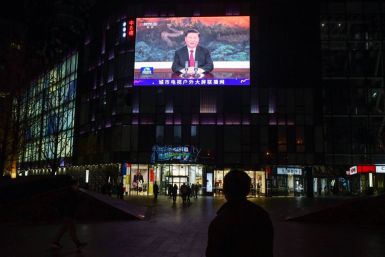 People walk below a giant screen at a shopping mall in Beijing showing news coverage of Chinese President Xi Jinping's speech to the virtual APEC summit