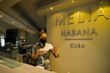 A receptionist sanitizes her hands at the Melia Habana Hotel in Havana -- Cuba is reopening its doors to foreign tourists after months of coronavirus-related closures, but will travelers return?