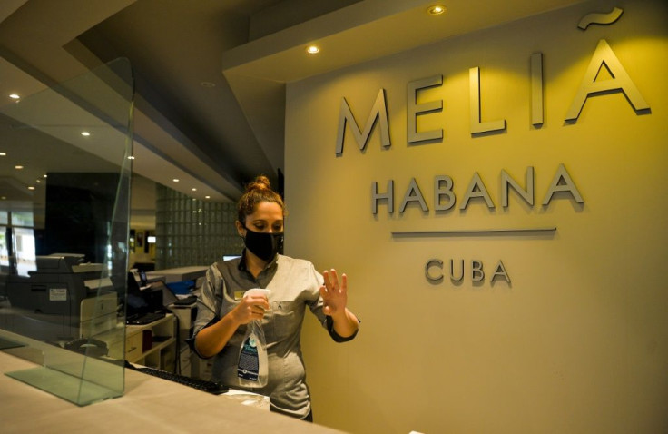 A receptionist sanitizes her hands at the Melia Habana Hotel in Havana -- Cuba is reopening its doors to foreign tourists after months of coronavirus-related closures, but will travelers return?
