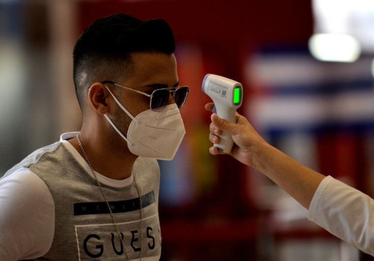 A passenger has his temperature checked at Havana's Jose Marti International Airport -- as the country reopens to tourists, the threat of imported coronavirus cases rises
