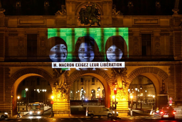 Amnesty International projects images of jailed Saudi activists including Loujain al-Athloul on the Louvre Museum in Paris
