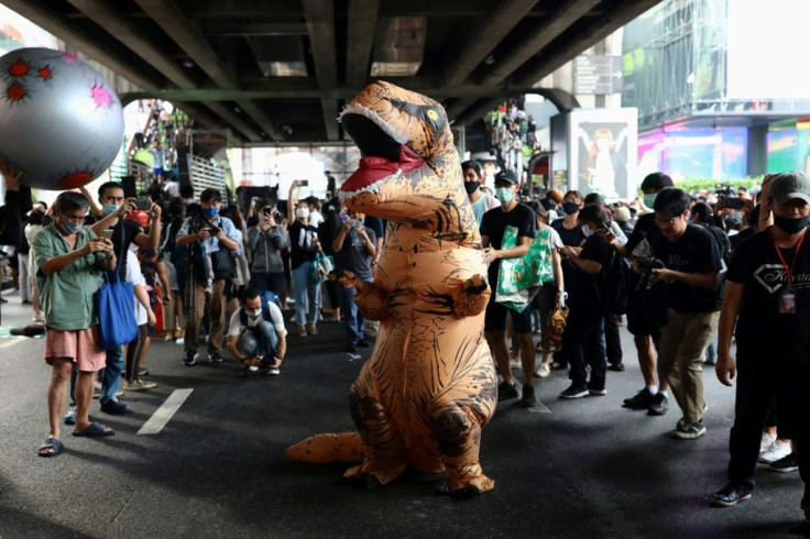 One dinosaur faces a threat from an 'asteroid' at the rally in Bangkok