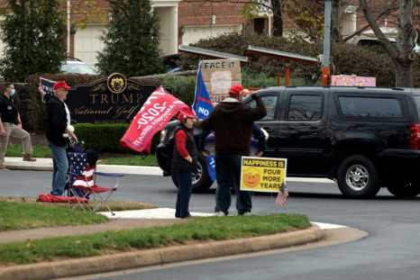 Supporters of -- and protesters against -- outgoing President Donald Trump watch his motorcade pass into the Trump International Golf Club in Sterling, Virginia on Saturday