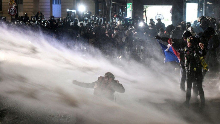 Police in Paris spray water cannon at protesters opposed to a French draft law seeking to limit the filming of police officers on duty.