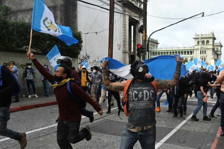 Demonstrators confront riot police during a protest demanding the resignation of Guatemalan President Alejandro Giammattei, in Guatemala City on November 21, 2020