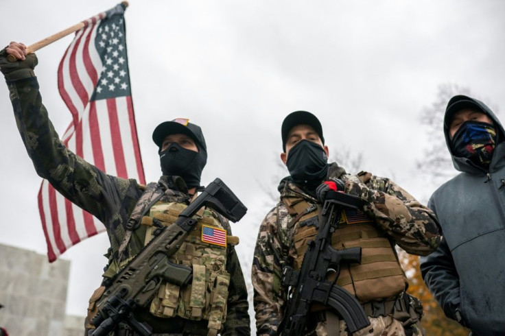 Armed protesters wave the US flag as they allege that President Donald Trump is being cheated out of an election victory in a November 14, 2020 rally in Salem, Oregon