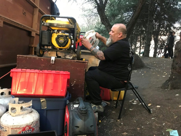 Homeless camp resident Guylain Levasseur pours fuel into one of the generators that provide electricity to a Montreal encampment set up in the summer of 2020