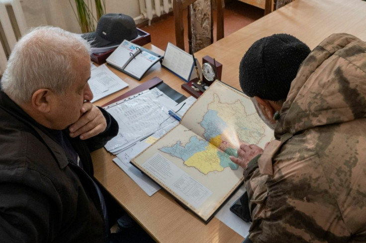 Armenian Vardges Harutyunyan (R) and Arvid Gulyan, Deputy head of Askeran district for agriculture look at the map of Nagorno-Karabakh and the Askeran district