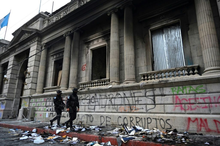 Police walk in front of the Guatemalan Congress a day after it was partly burned during a protest demanding the resignation of President Alejandro Giammattei, in Guatemala City on November 22, 2020