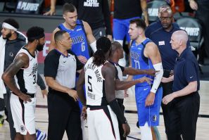 Officials get between Luka Doncic #77 of the Dallas Mavericks and Marcus Morris Sr. #31 of the LA Clippers