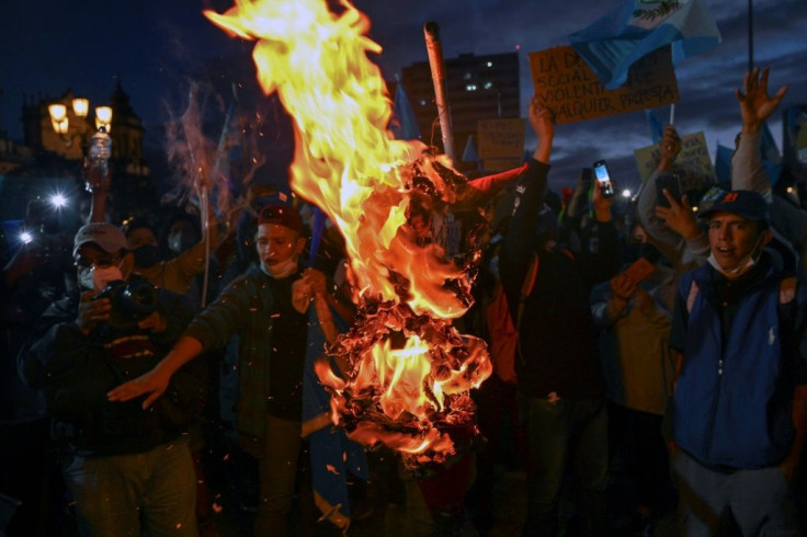 Demonstrators burn an effigy representing Guatemalan President Alejandro Giammattei during a protest demanding his resignation