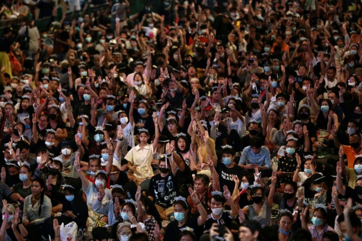 Pro-democracy protesters hold up the three-finger salute at a pro-democracy protest in Bangkok