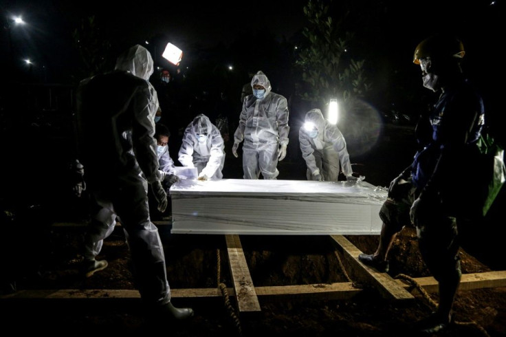 Gravediggers work during a funeral for a COVID-19 victim in Bogor, Indonesia.