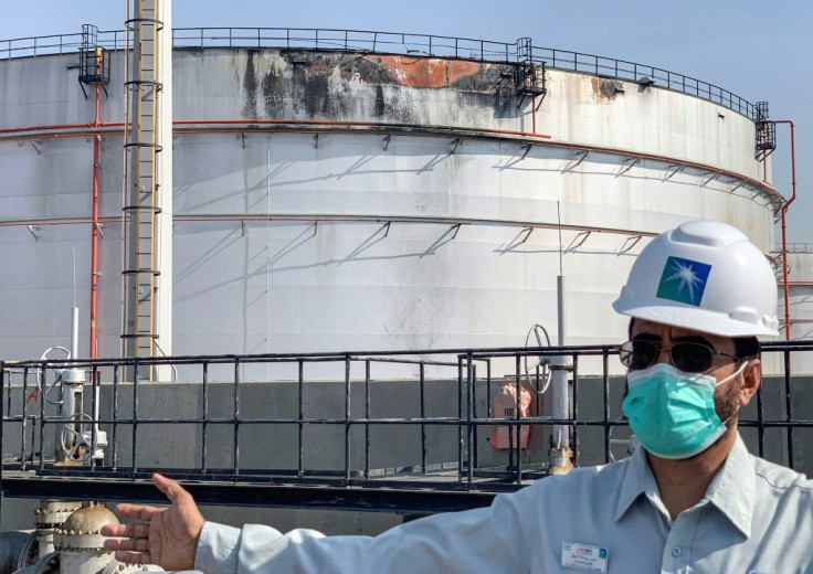 An employee at the Saudi Aramco oil facility in Jeddah on Tuesday stands near a tank that was damaged in a strike a day earlier