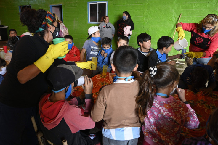 hildren -some of them wearing face masks against the spread of the new coronavirus, COVID-19- prepare to have their afternoon milk at a community eatery during the lockdown imposed by the government in Jose C. Paz, Buenos Aires, Argentina.