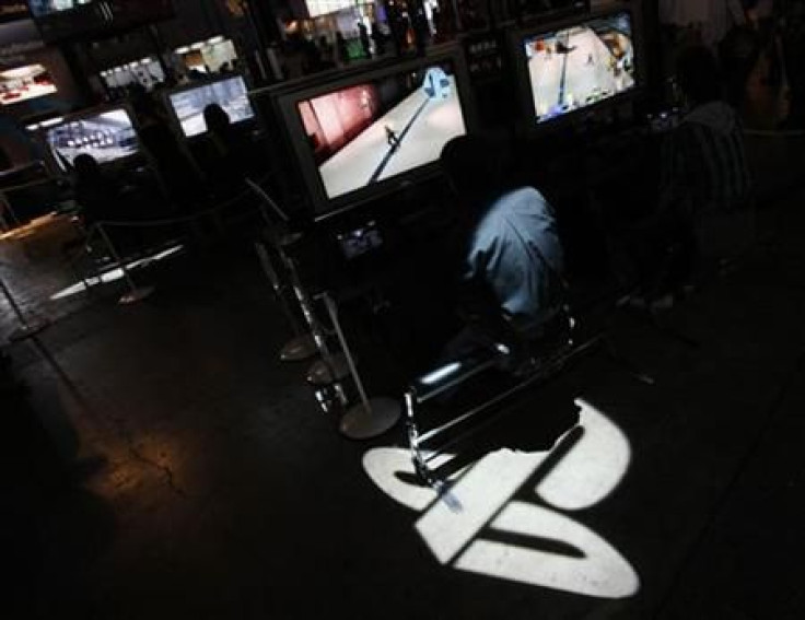 Man plays Sony&#039;s PlayStation 3 game console as logo of Sony&#039;s PlayStation displayed at the Tokyo Game Show in Chiba