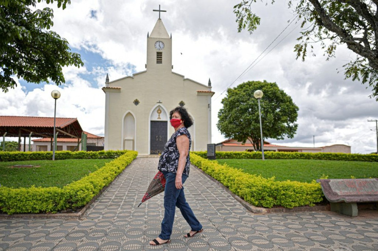 A woman walks past the church in Cedro do Abaete, the only Brazil town without a case of Covid-19