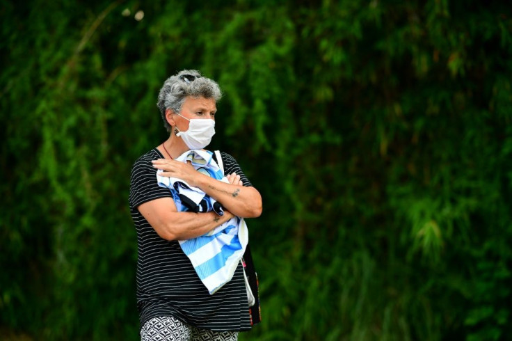 A woman holding a jersey mourns outside the gated community where Argentine football star Diego Maradona's home is located, in Benavidez, Buenos Aires province, where he died on November 25, 2020