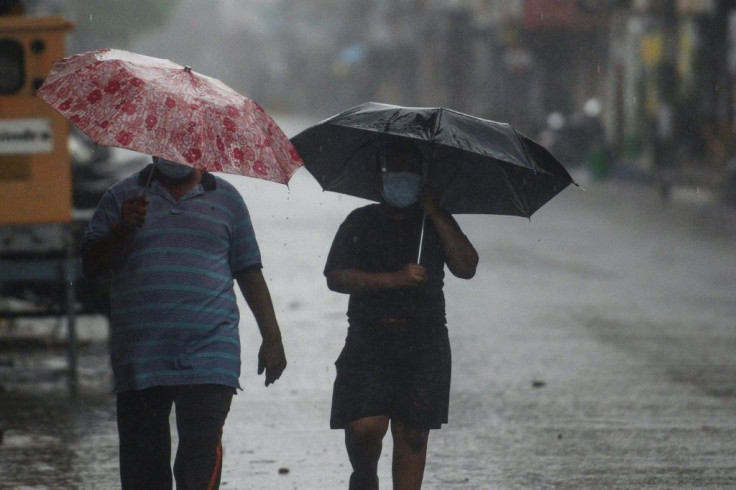 Residents walk along a deserted road as Cyclone Nivar approached the southeastern Indian coast in Puducherry on November 25, 2020