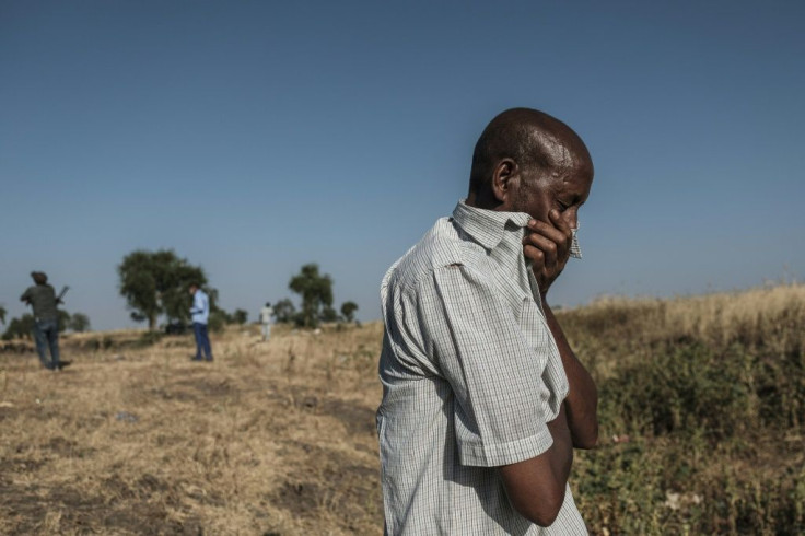 A man reacts near a body-filled ditch outside Mai-Kadra, where 600 civilians are believed to have been massacred