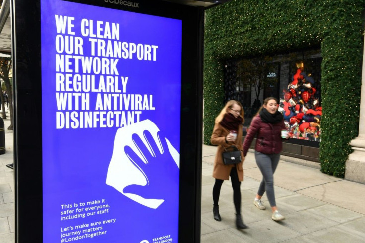 Pedestrians walk past a sign about how the public areas of the transport network are disinfected regularly as a hygiene precaution during the novel coronavirus pandemic on Oxford Street in London