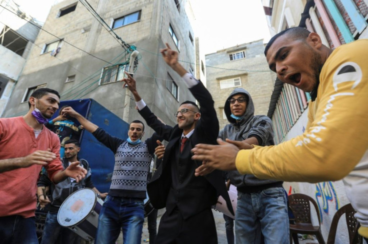 Palestinian groom Mohammed Ahmed Ashour (C) dances with male relatives and friends while waiting for his bride during his wedding ceremony amid the COVID-19 pandemic, in Gaza City