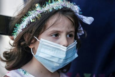 A Palestinian girl waits for a bride while wearing a protective mask due to the COVID-19 pandemic. To contain the spread of coronavirus, the Hamas Islamist group has banned large indoor gatherings