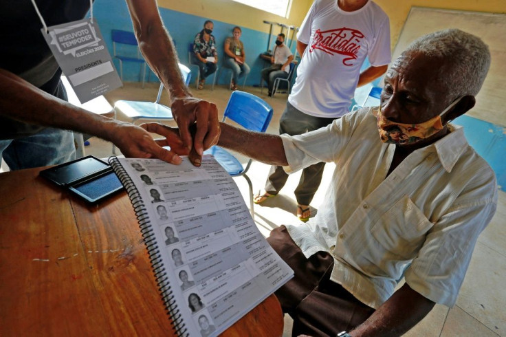 A man votes using his fingerprint to sign at a polling station in Igarape Miri, Para state, Brazil during the first round of municipal elections amid the new coronavirus pandemic on November 15, 2020