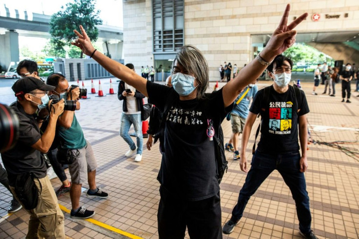 Hong Kong judges on Friday ruled that prison staff had been wrong to cut the hair of activist Leung Kwok-hung (C), known as 'Long Hair' for his silver locks