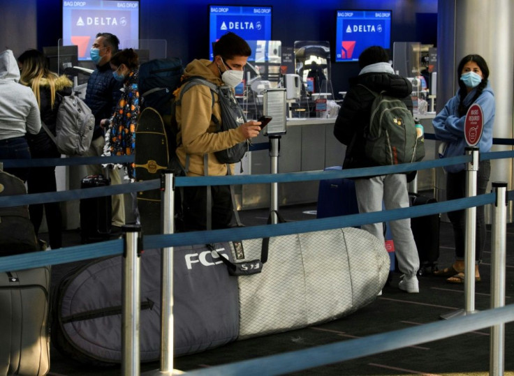 Passengers wait in line to check-in for Delta Air Lines flights at Los Angeles International Airport ahead of the Thanksgiving holiday in Los Angeles, California, on November 25, 2020