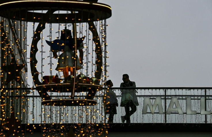 Customers stand on a balcony next to Christmas decorations in a shopping mall in Berlin. Germany plans to ease virus curbs for Christmas