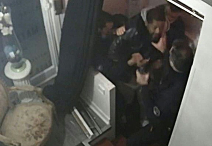 Producer Michel Zecler (L) is seen grabbed by police officers at the entrance of a Paris music studio in this screen grab of an AFP video taken from security camera footage that shows him beaten repeatedly.
