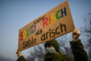 Anti-AfD protesters gathered at the site Friday afternoon -- this woman's banner reads 'rather in solidarity than solid Aryan'