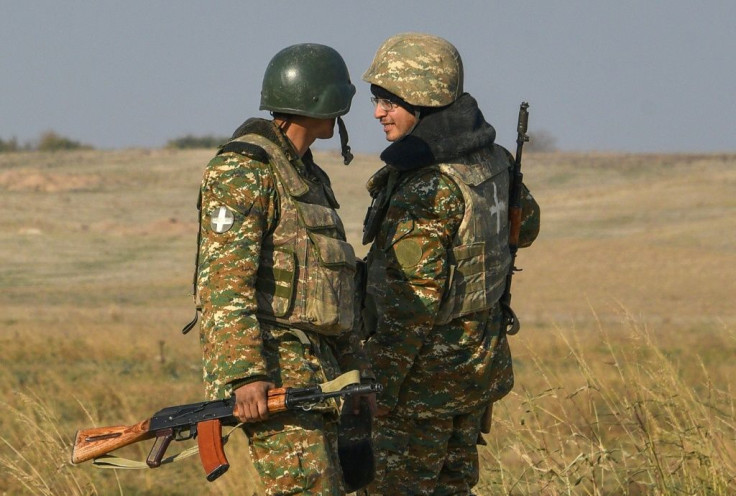 Armenian soldiers patrol a road outside the village