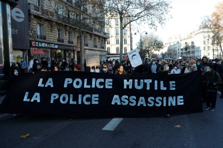 Demonstrators hold a sign reading 'Police mutilate police kill' on the Place de la Republique in Paris