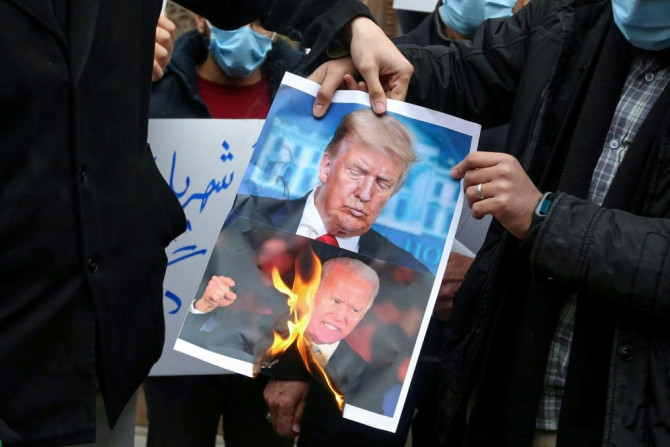 Students in Tehran burn posters depicting US President Donald Trump ( and President-elect Joe Biden during a rally on November 28, 2020 to protest the killing of nuclear scientist Mohsen Fakhrizadeh