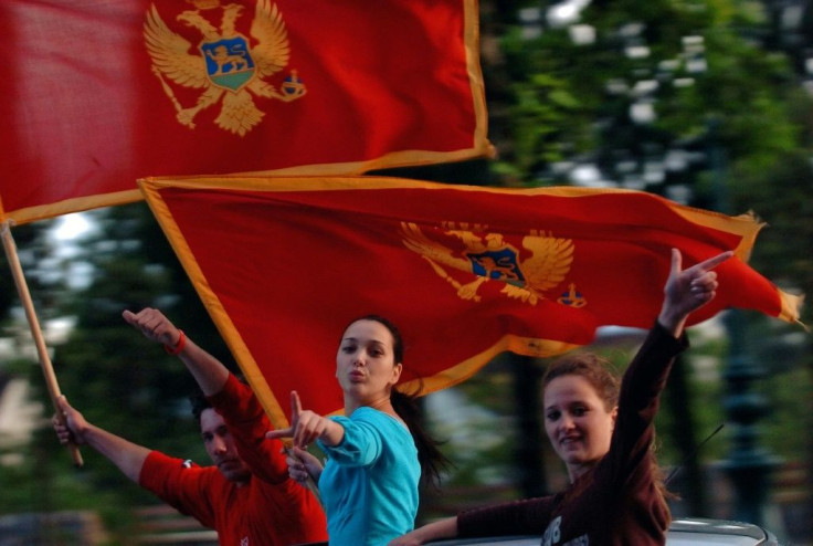 People wave Montenegro's flag in Podgorica in June 2006 following the country's formal declaration of independence from Serbia, although tensions around national identity still haunt the tiny Balkans nation to this day