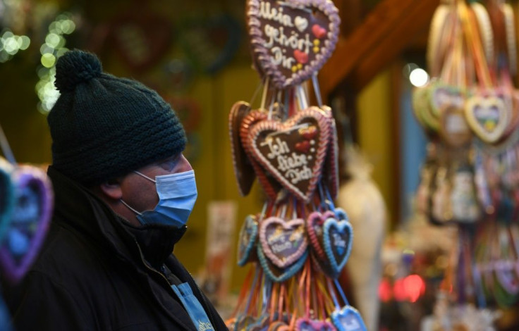 An employee wears a protective mask at a sales booth at the drive-in Christmas market in Landshut