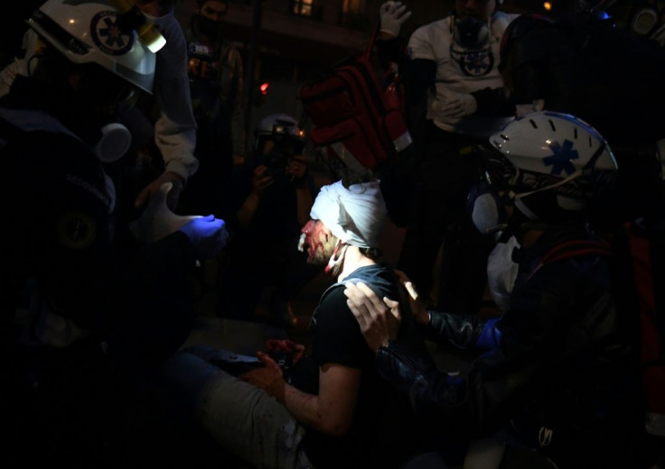 Medics tend to Ameer Alhalbi after he was injured at a Paris rally against a 'global security' draft law, which would criminalise publication of images of on-duty French police officers