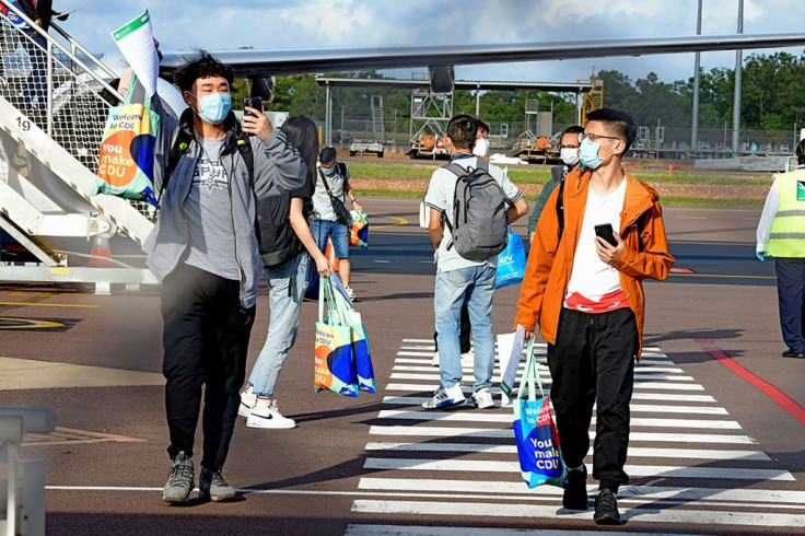 Foreign students disembark from an international flight at Darwin Airport, the first such arrivals since Australia's border closure in March