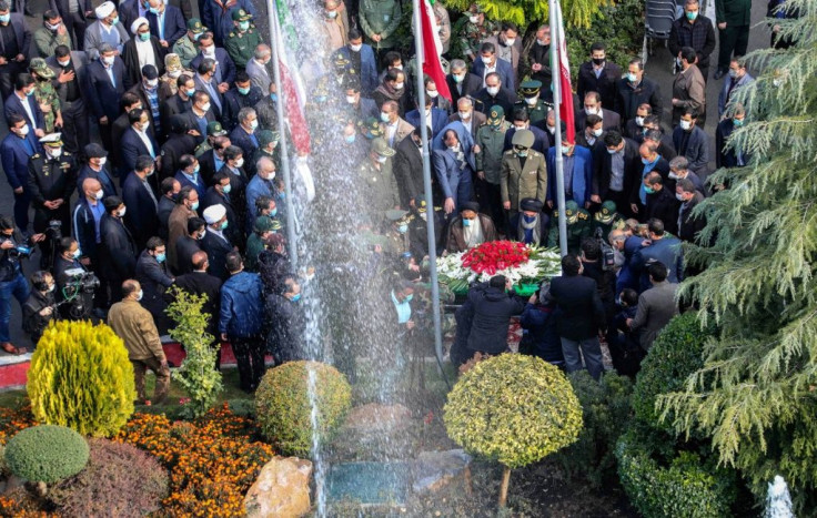 Iranian officials pray over the coffin of top nuclear scientist Mohsen Fakhrizadeh during his funeral in Tehran on Monday, in this picture provided by the country's defence ministry