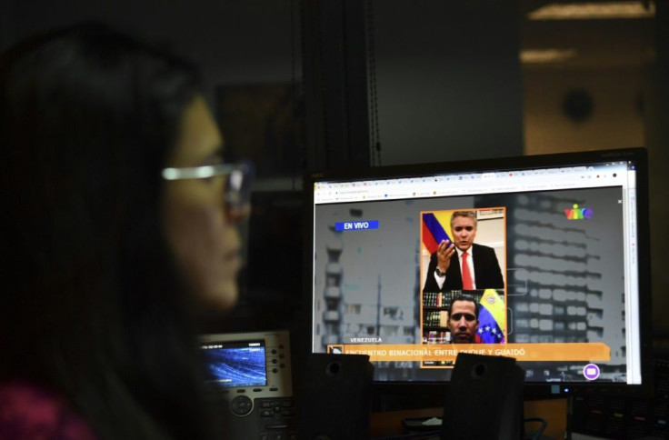 A journalist follows live a 2019 online encounter between Colombian President Ivan Duque and Venezuelan opposition leader Juan Guaido from a computer in Caracas, where the United States accuses China of helping restrict the internet