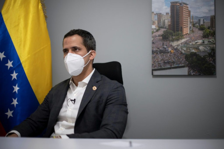 Venezuelan opposition leader Juan Guaido's home office features a national flag and a picture of a demonstration he led in 2019 -- protests that are increasingly rare in the country