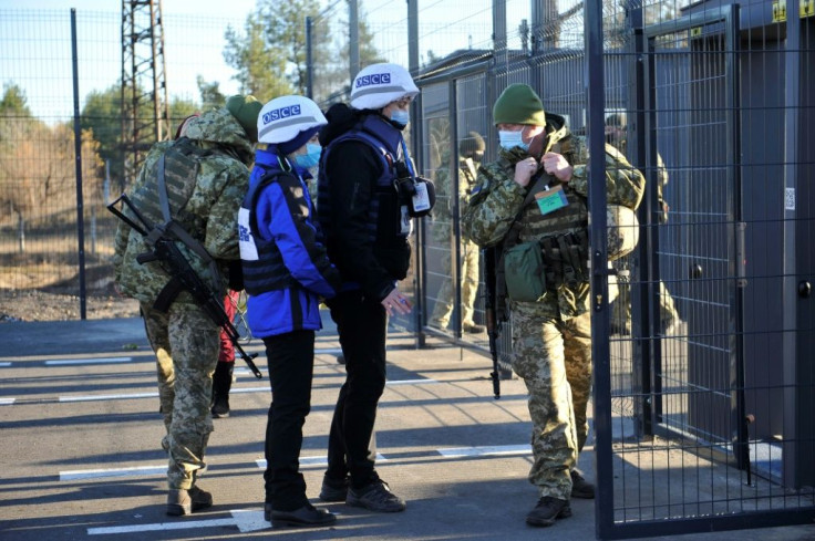 Ukrainian border guards look on as OSCE observers cross a checkpoint between the Kiev-controlled territory and occupied areas in the war-torn east last month