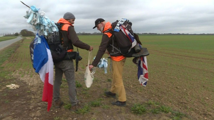 Environmental activists Frederic Munsch (L) and Edmund Platt (R) bag trash, including coronavirus masks, along the TGV train route from Marseille to Paris